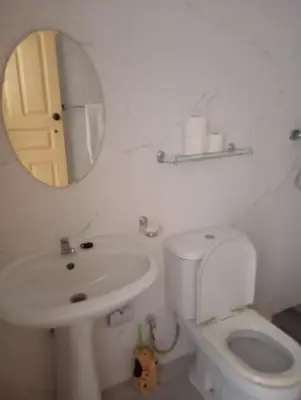 a bathroom with a toilet and a sink and a mirror at Edu Horizonte in Calheta de São Miguel