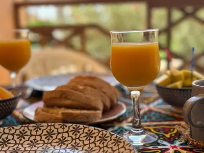 a table with a glass of orange juice and bread at Tropical Issara Sal in Santa Maria