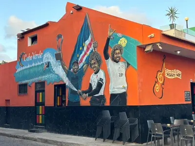 a mural of three people on the side of a building at Tropical Issara Sal in Santa Maria
