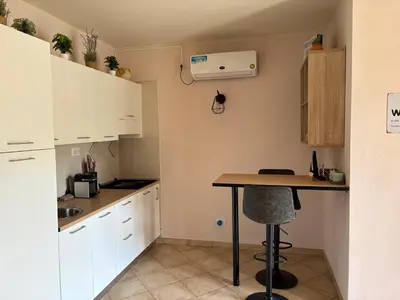 a small kitchen with white cabinets and a table at Tropical Issara Sal in Santa Maria