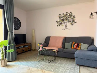 a living room with a blue couch and a table at Tropical Issara Sal in Santa Maria