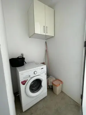 a white washing machine in a room with a cabinet at Casa do Encanto in Praia
