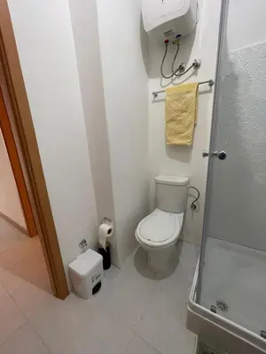 a small bathroom with a toilet and a shower at Casa do Encanto in Praia