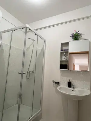 a bathroom with a glass shower and a sink at Casa do Encanto in Praia
