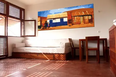 a living room with a couch and a painting on the wall at Paz Apartment in Mindelo