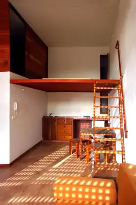 a room with a bunk bed and a table and a ladder at Paz Apartment in Mindelo