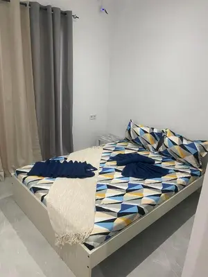 a bed in a bedroom with blue pillows on it at Apartamento em Pedra Badejo in Pedra Badejo