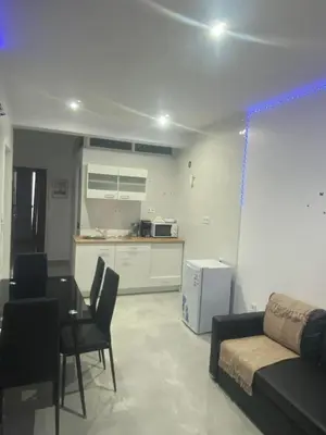 a living room with a couch and a table and a kitchen at Apartamento em Pedra Badejo in Pedra Badejo