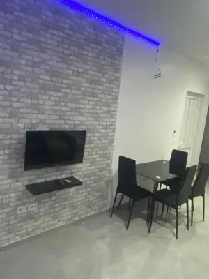 a dining room with a table and chairs and a brick wall at Apartamento em Pedra Badejo in Pedra Badejo