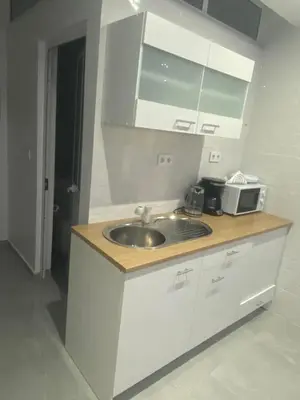 a kitchen with a sink and a microwave at Apartamento em Pedra Badejo in Pedra Badejo