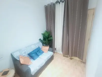 a blue couch in a room with a plant at 1 chambre proche aeroporto cabo verde in Espargos