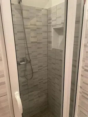 a shower stall with a glass door with a shower at 1 chambre proche aeroporto cabo verde in Espargos