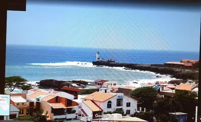 a lighthouse on the beach with houses and a town at Gamboa Djeu in Praia