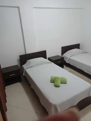 two beds in a room with two green towels at Gamboa Djeu in Praia