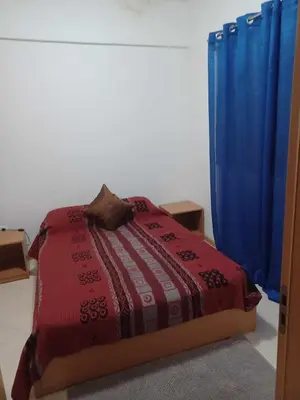 a bedroom with a bed and a blue curtain at Gamboa Djeu in Praia