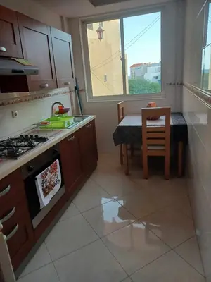 a kitchen with a stove top oven next to a table at Gamboa Djeu in Praia