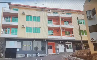 an apartment building with orange doors and windows at Gamboa Djeu in Praia