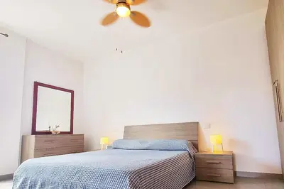 a bedroom with a bed and a ceiling fan at Modern apartment in the Center in Sal Rei