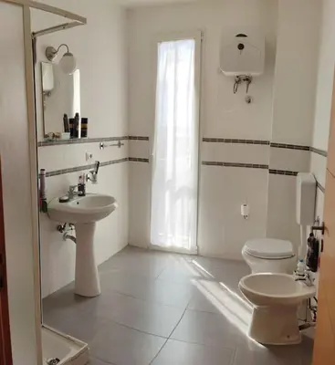 a white bathroom with a toilet and a sink at Modern apartment in the Center in Sal Rei