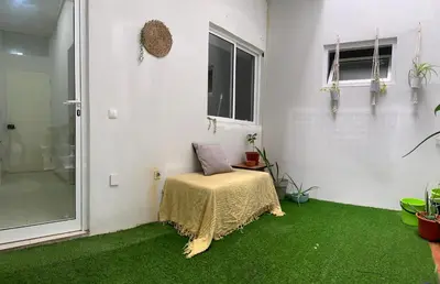 a room with a table and green carpet at Flat Mindelo 30 in Mindelo