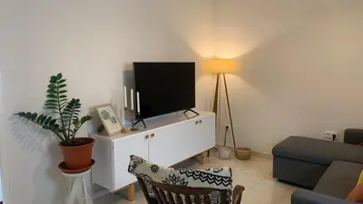 a living room with a tv on a white cabinet at Flat Mindelo 30 in Mindelo