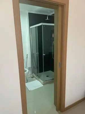 a bathroom with a glass shower and a toilet at Meraki's Apartment in Praia