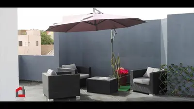 a patio with two chairs and an umbrella at Guest House Lina Elisa in Mindelo