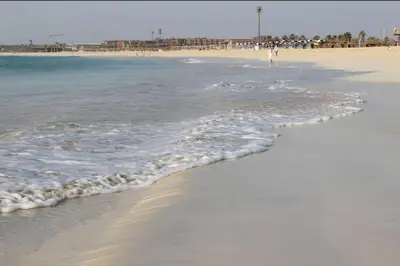 a beach with the ocean and people walking on it at Oceanfront Apt 25 Porto Antigo II in Santa Maria