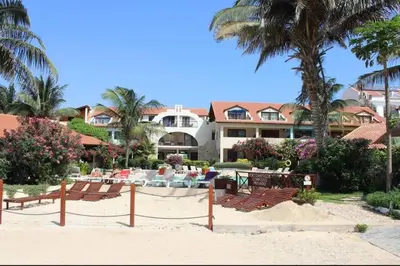 a resort with chairs and tables on the beach at Oceanfront Apt 25 Porto Antigo II in Santa Maria