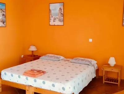 a bedroom with a bed with an orange wall at Estudio para dos personas-Stella Maris Villa FREE PICK UP in Calheta Do Maio