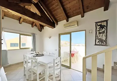 a dining room with a white table and white chairs at Bright Top Floor with Terrace in Santa Maria