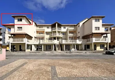 a large apartment building with a car parked in front at Bright Top Floor with Terrace in Santa Maria