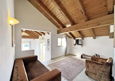 a living room with a couch and wooden ceilings at Bright Top Floor with Terrace in Santa Maria