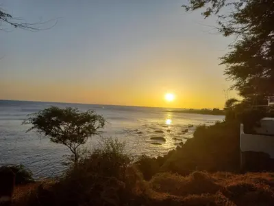 a sunset over the water with the sun setting at Brisa e Paz in Praia