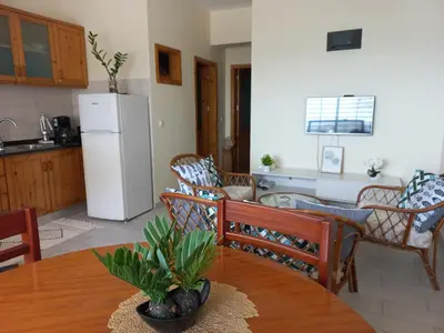 a kitchen and dining room with a table and a refrigerator at Brisa e Paz in Praia