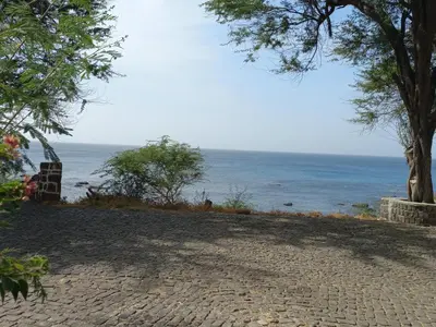 a cobblestone road leading to a beach with the ocean at Brisa e Paz in Praia