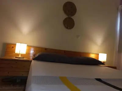 a bedroom with a bed with two lamps on it at Brisa e Paz in Praia