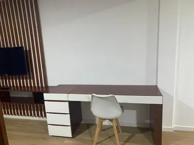 a desk with a white chair and a desk with a television at Mota Residência in Santa Maria