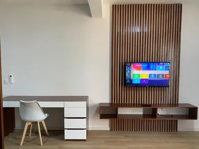 a room with a desk and a television on a wall at Mota Residência in Santa Maria