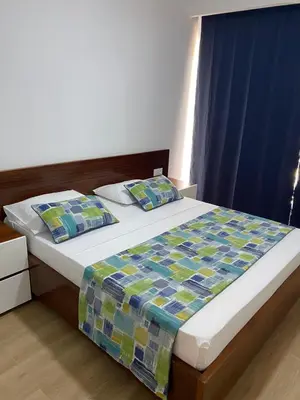 a bedroom with a bed with a blue curtain at Mota Residência in Santa Maria