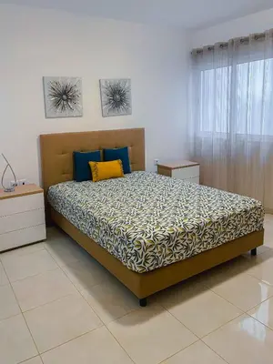 a bedroom with a bed with blue and yellow pillows at Apartamento Paradise in Santa Maria