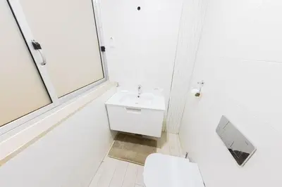 a white bathroom with a sink and a toilet at Jet Ap & Car 12 - AC in Praia
