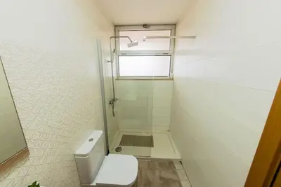 a white bathroom with a shower and a toilet at Jet Ap & Car 12 - AC in Praia