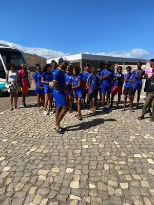 a group of people in blue shirts standing on a street at Cabo Verde Beach Sport Resort in Porto Novo