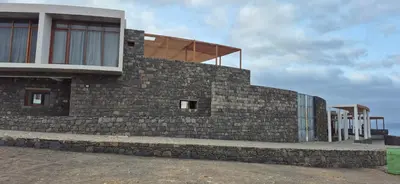 a building with a stone wall with windows at Cabo Verde Beach Sport Resort in Porto Novo
