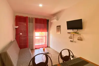 a living room with a table and chairs and a television at A Baia do Fortim in Mindelo