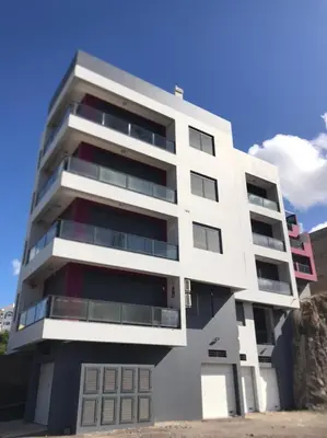 a white building with balconies on the side of it at A Baia do Fortim in Mindelo