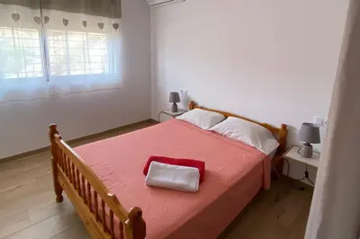 a bedroom with a large bed with a red blanket at A Baia do Fortim in Mindelo