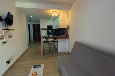 a living room and kitchen with a couch and a table at A Baia do Fortim in Mindelo