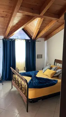 two beds in a room with blue curtains at Soleil A9 in Santa Maria